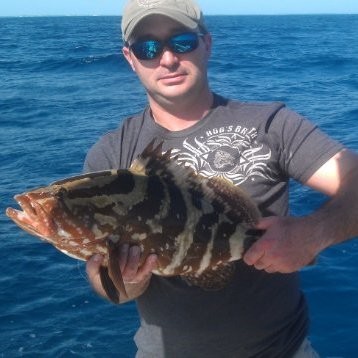 Capt. Nick Neuberg a man holding a fish in the water